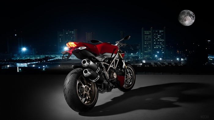 Red Ducati Motorcycle at Night with Cityscape and Moon