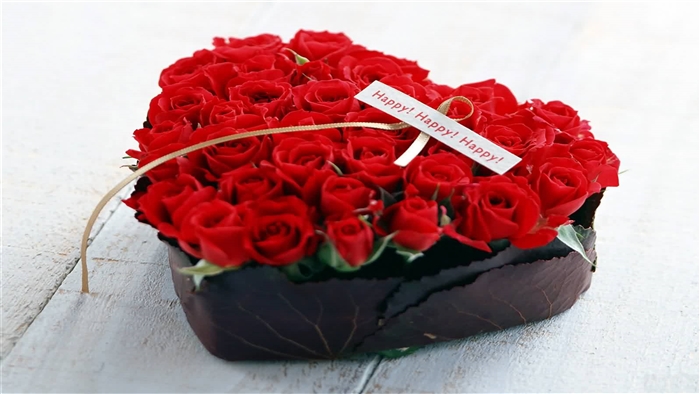 Heart-shaped arrangement of red roses with "Happy! Happy! Happy!" card