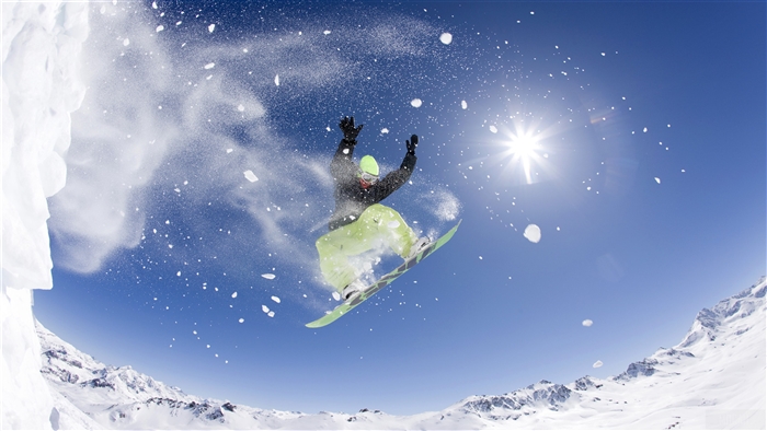 Snowboarder jumping in the air with snow spray