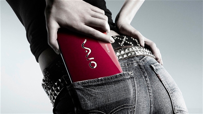 Woman putting red Sony VAIO laptop in back pocket