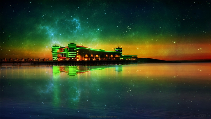 Pier building with neon lights reflected in water under starry sky