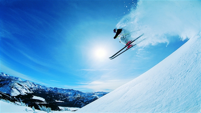 Skier jumping in the air with snow spray