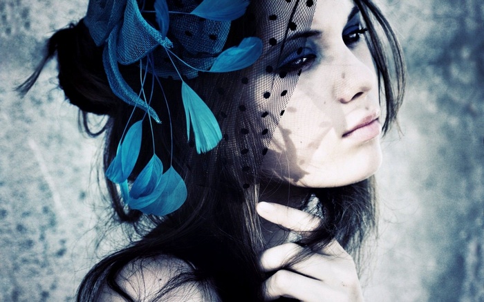 Woman with blue feathers and veil