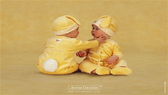 Two babies in yellow bunny outfits