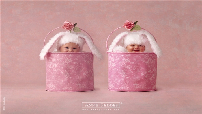 Two babies in bunny hats in pink buckets
