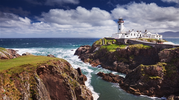 White Lighthouse on Rocky Coastline Overlooking Ocean