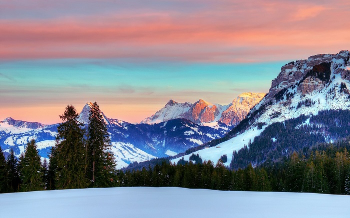 Snowy mountains at sunset with colorful sky