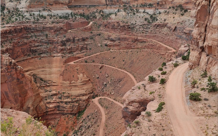 Winding dirt road through a desert canyon