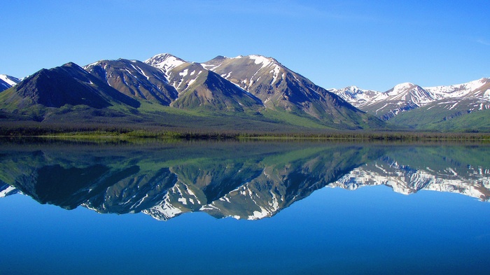 Snow-capped mountains reflected in a calm lake