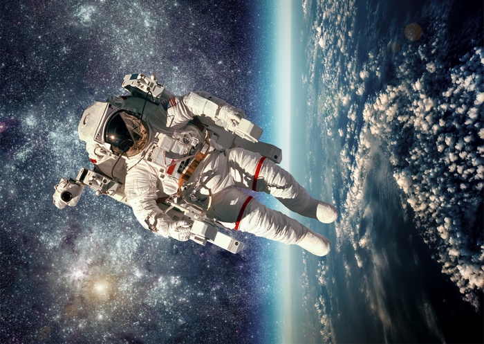 Astronaut floating in space above Earth