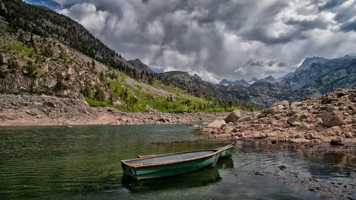 Two green boats on a lake with mountains