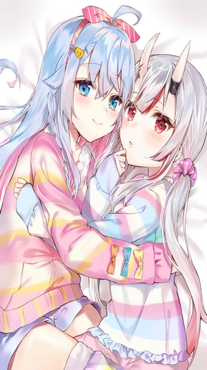Two anime girls hugging on a bed