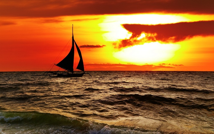 Sailboat on the ocean during a vibrant sunset