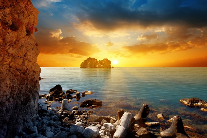 Sunset over the sea with rocky shore