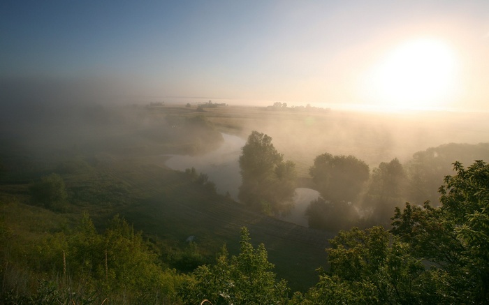 Misty river valley at sunrise