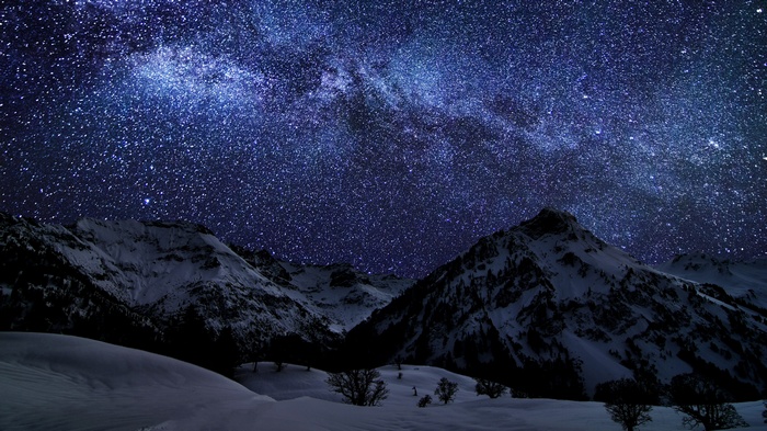 Milky Way over snow-covered mountains at night
