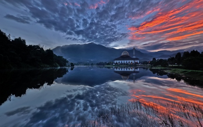 Mosque reflected in a lake at sunset