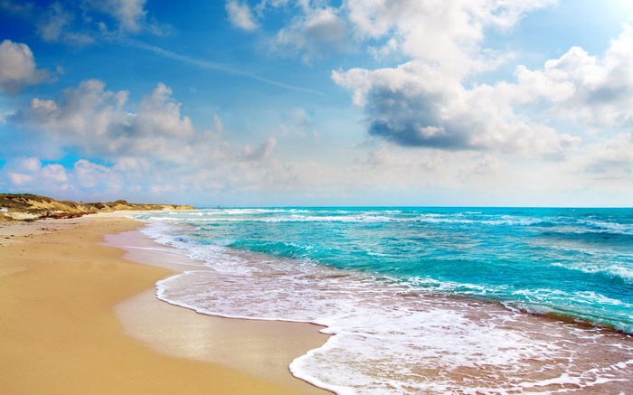 Beach with turquoise ocean and cloudy sky