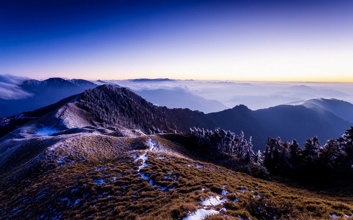 Mountain range at sunrise with clouds and snow