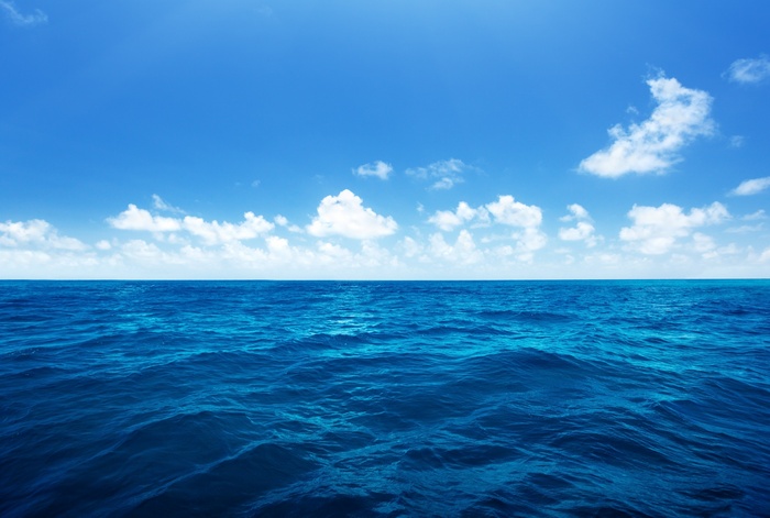 Blue ocean and sky with clouds