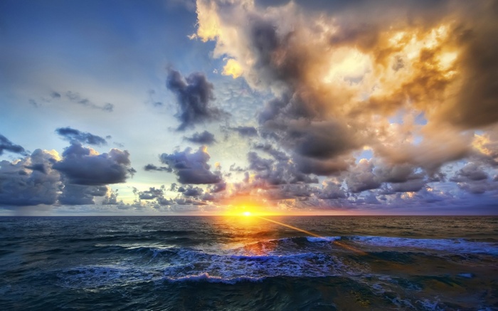 Sunset over the ocean with dramatic clouds
