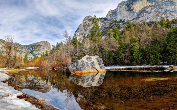 Mountain landscape with a lake and a large boulder