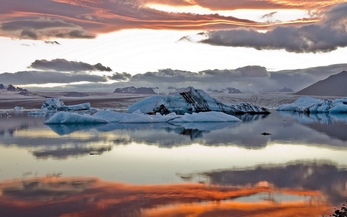 Icebergs floating in a lake at sunset