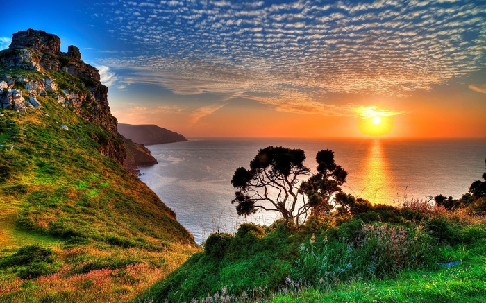 Sunset over the ocean with coastal cliffs