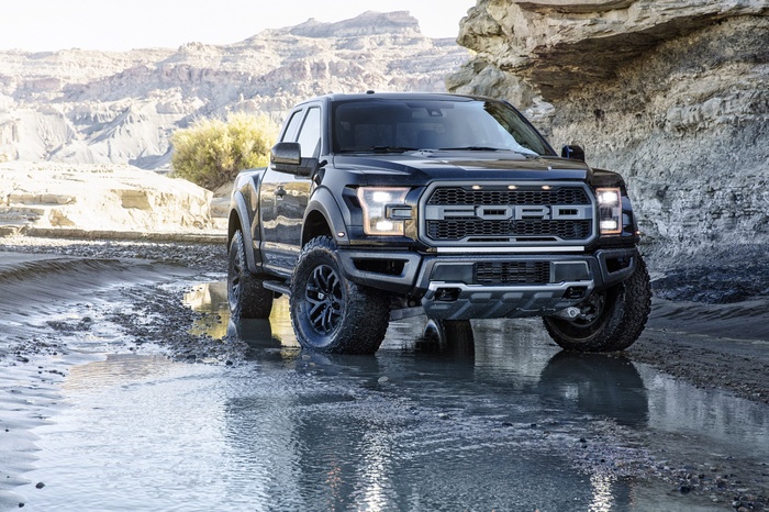 Black Ford F-150 Raptor driving through water
