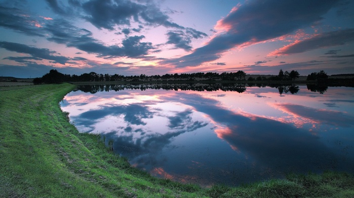 Sunset over a calm lake with reflections
