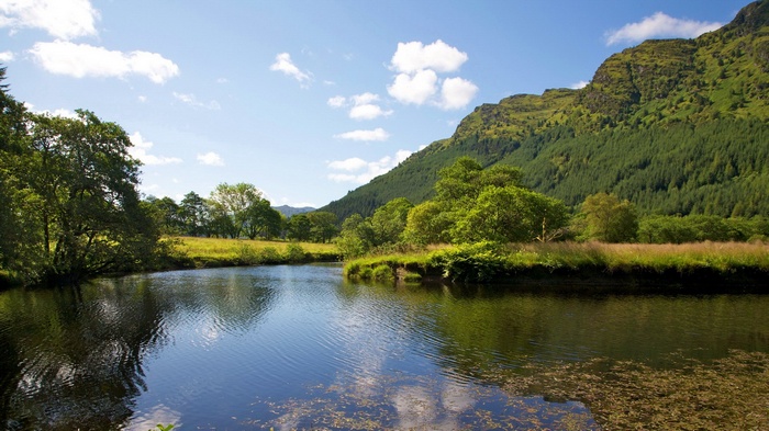 River flowing through a green valley with mountains