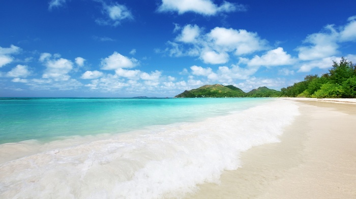 Tropical beach with turquoise water and green hills