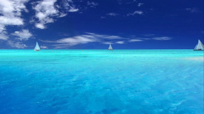 Sailboats on a turquoise ocean under a blue sky