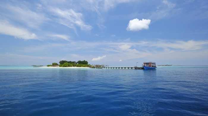 Island with a pier and a boat in the ocean