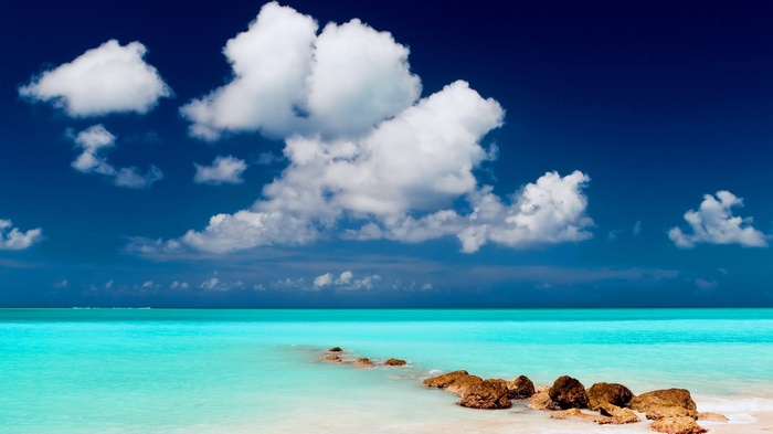Turquoise ocean and blue sky with clouds