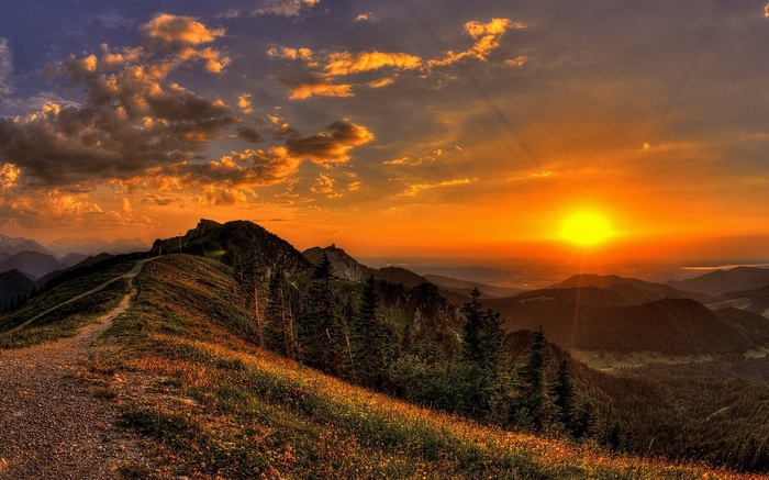 Sunset over mountain range with a hiking path