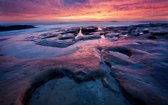 Rocky coastline at sunset with colorful sky
