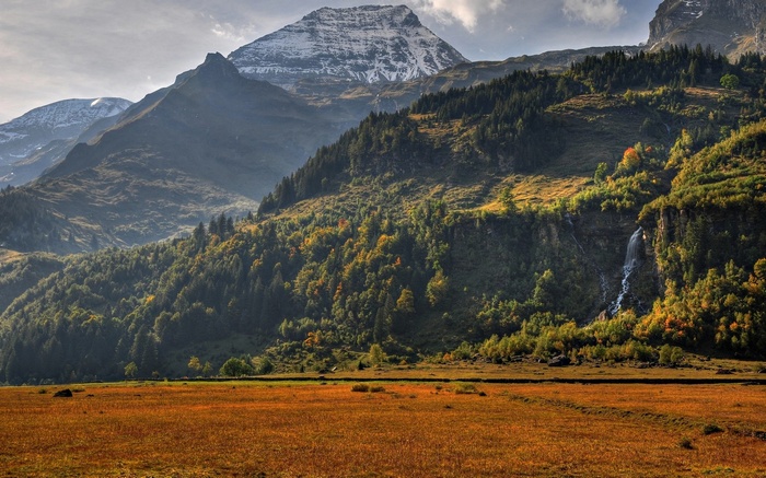 Mountain landscape with autumn trees and a waterfall