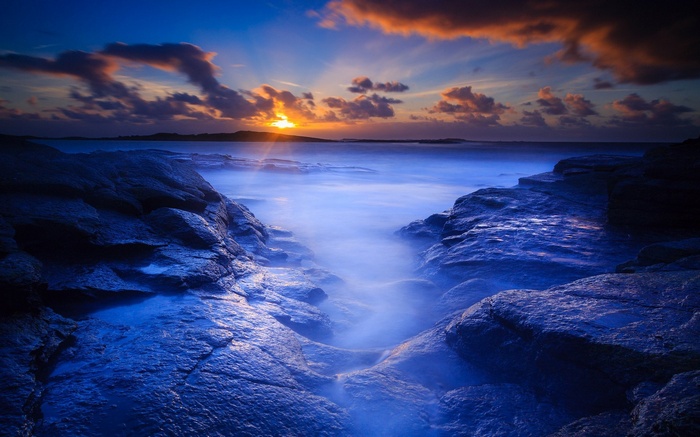Rocky coastline at sunrise with misty ocean