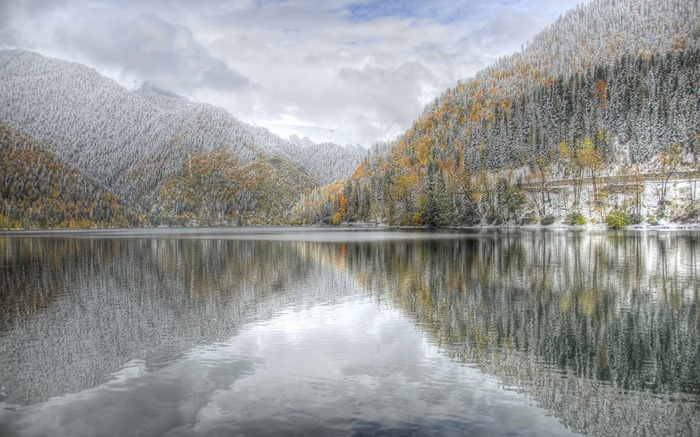 Snow-dusted mountains reflected in a calm lake