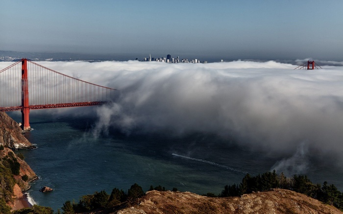 Golden Gate Bridge shrouded in fog with San Francisco skyline