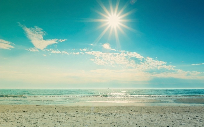 Sunny beach with ocean waves and sand