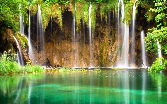Waterfalls cascading into a turquoise lake in a forest