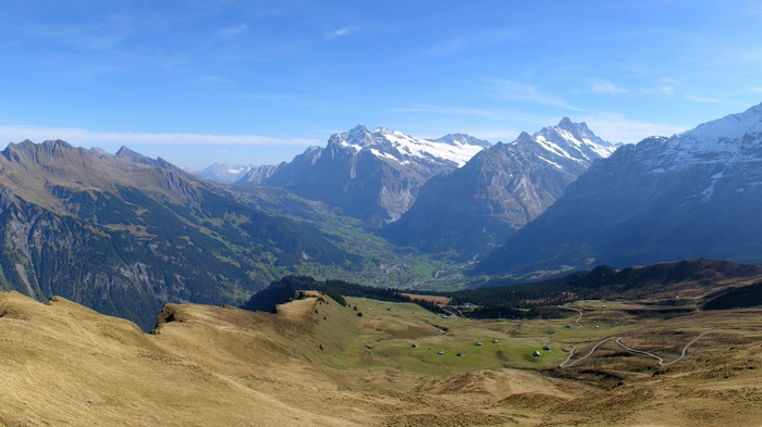 Panoramic view of a mountain valley with snow-capped peaks