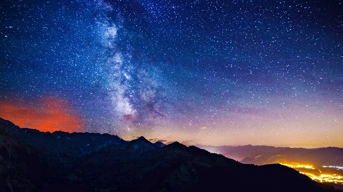 Milky Way over mountains and city lights