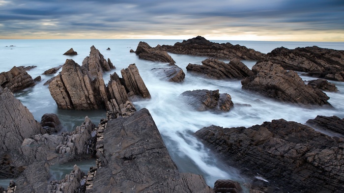 Jagged rocks in the ocean with blurred water