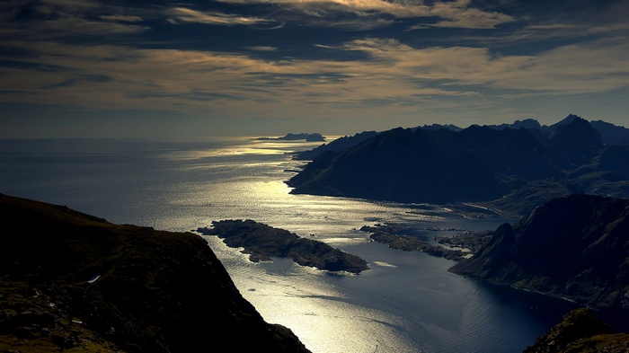 Sunlight reflecting on water between mountains