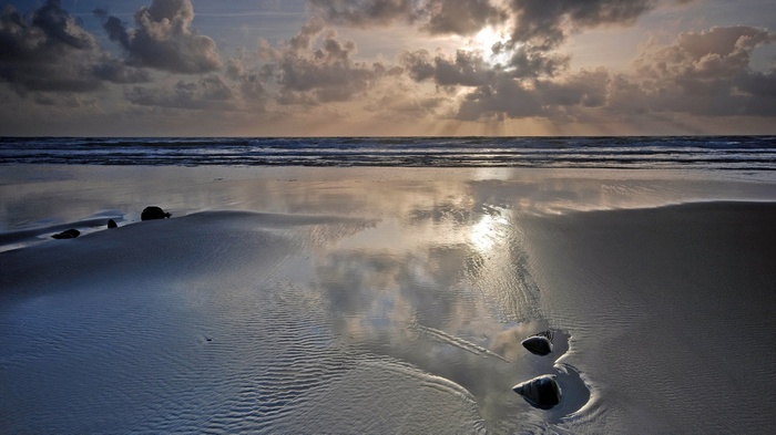 Beach at sunset with reflections