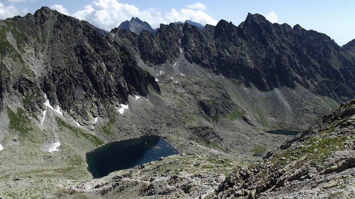 Mountain range with a dark lake and rocky slopes
