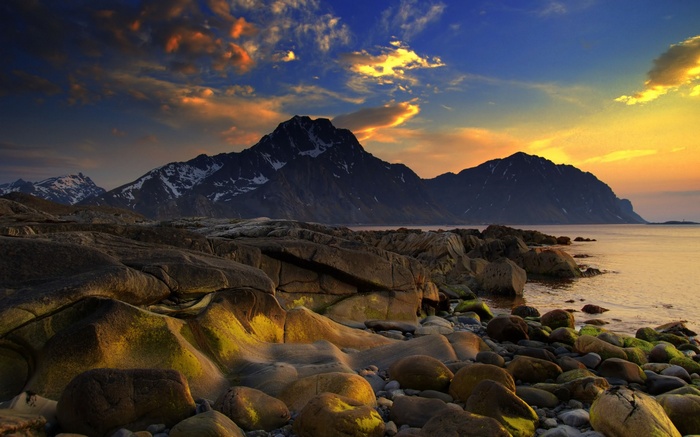 Rocky coastline with mountains at sunset